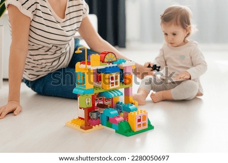 Mother and child daughter playing together, build from the constructor