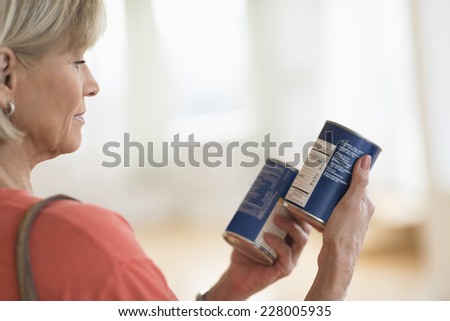 Cropped image of woman comparing products in shop Royalty-Free Stock Photo #228005935
