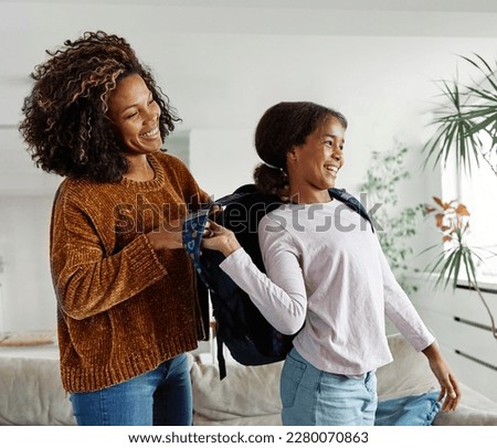 Mother helping daughter to get ready for school, helping her with backpack and books,hugging and leaving home  Royalty-Free Stock Photo #2280070863