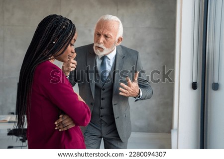 Furious senior businessman company manager yelling at young businesswoman putting her under pressure in office. Sad businesswoman experiencing harassment at work sadly looking at the floor. Royalty-Free Stock Photo #2280094307