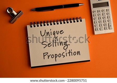 There is a notebook with the word Unique Selling Proposition. It is eye-catching image.
