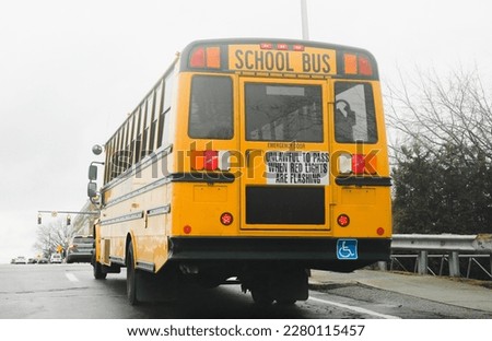 yellow school bus parked on a quiet suburban street. The bus is bright yellow with tinted windows and a stop sign on the side. photo conveys a sense of safety and nostalgia.
