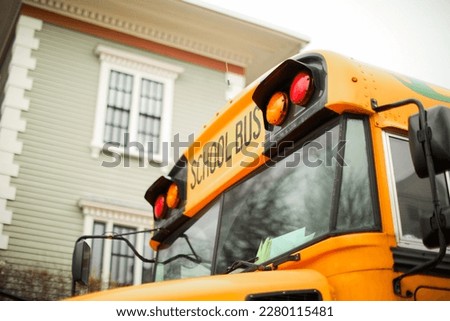 yellow school bus parked on a quiet suburban street. The bus is bright yellow with tinted windows and a stop sign on the side. photo conveys a sense of safety and nostalgia.