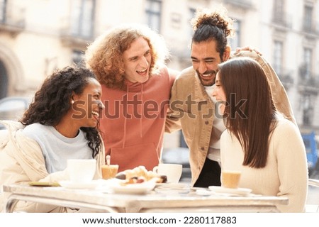 Two female friends having breakfast on the terrace of the bar while 2 guys come over to flirt. High quality photo
