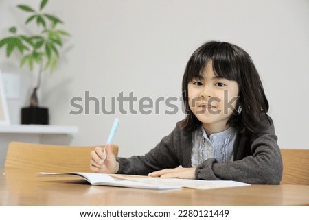 Japanese student girl studying in dining room (8 years old) Royalty-Free Stock Photo #2280121449