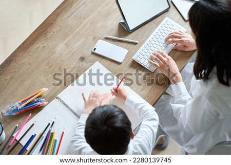 A mother working in her room and a child drawing Royalty-Free Stock Photo #2280139745