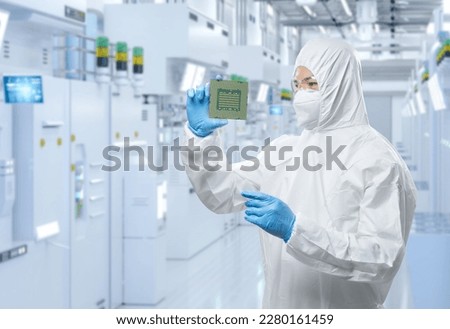 Worker or engineer wears medical protective suit or white coverall suit with chipset in semiconductor factory Royalty-Free Stock Photo #2280161459