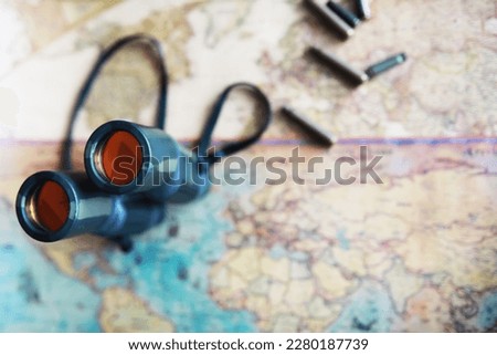 Binoculars and reflection in lenses. Map background.