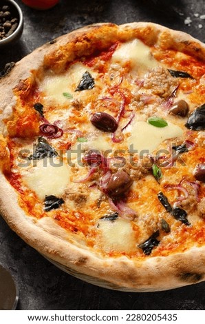 Tuna Pizza, Freshly Baked Pizza with Tuna, Mozzarella, Onion, Basil, and Olives on Dark Rustic Background