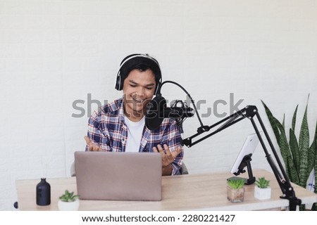 Attractive young Asian man radio host talking during podcast.