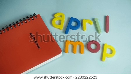April mop words in various color and note book isolated in white background or blue background 
