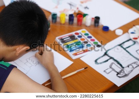Student is studying art subject, drawing and painting. Concept, art activity. Boy enjoy and concentrate on his favorite activity. Education. Learning by doing and  imagination.                       
