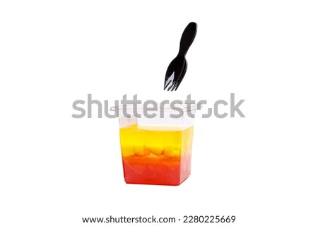 Grapefruit, mango and raspberry jelly in a plastic cup on a white background. High quality photo