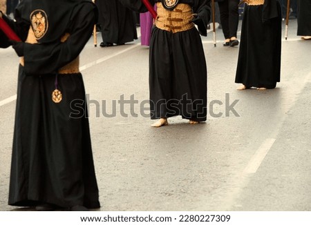 The Nazarenes of the Brotherhood of Jesus of the Great Power wear black tunics with espadrille grass belts and process barefoot in silent procession during the Andalusian Holy Week.