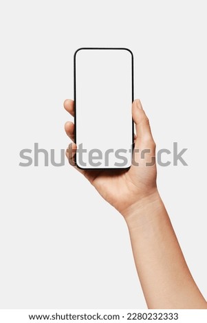 Close up of woman hand holding modern smart phone mockup. New modern black frameless smartphone mockup with blank white screen. Isolated on white background high quality studio shot Modern smart Royalty-Free Stock Photo #2280232333