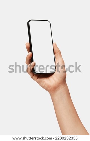 Close up of woman hand holding modern smart phone mockup. New modern black frameless smartphone mockup with blank white screen. Isolated on white background high quality studio shot Modern smart Royalty-Free Stock Photo #2280232335