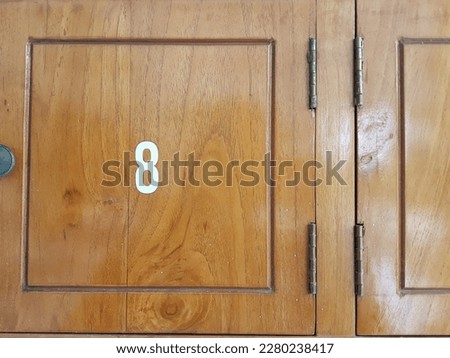 A wooden locker with a number, nomor urut numeric 41 8,di lemari laci loker kayu, terlihat menarik dengan bentuk loker yang segi empat dan terbuat dari bahan kayu jati yang difinishing halus dan rapi