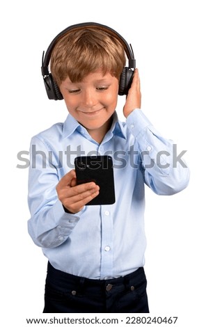 Smiling child in headphones looking at smartphone, isolated over white background. Concept of video call, online education and mobile app