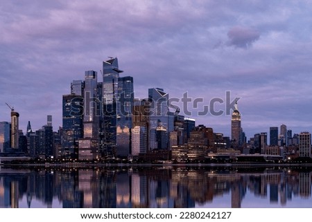 Reflection of New York city skyscrapers in the water in the evening. New York, the United States of America. Concept of sightseeing and tourism