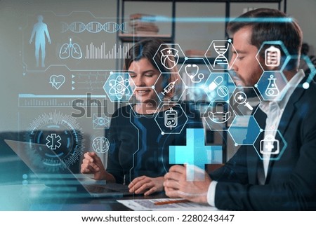 Thoughtful businesspeople typing on laptop at office workplace. Concept of team work, business education, internet surfing, brainstorm, project information technology. Medical healthcare hologram Royalty-Free Stock Photo #2280243447