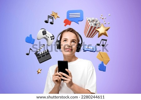 Portrait of smiling young woman using smartphone and headphones standing over purple background with online entertainment icons Royalty-Free Stock Photo #2280244611