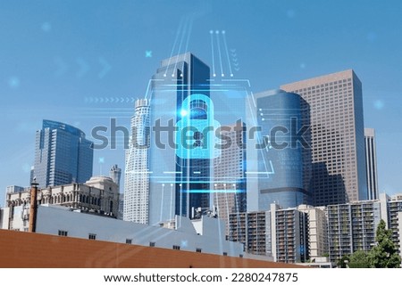 Panorama cityscape of Los Angeles downtown at day time, California, USA. Skyscrapers of LA city. Glowing Padlock hologram. The concept of cyber security to protect companies confidential information