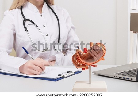 Young beautiful doctor woman working happy and smile in hospital, sitting on table, mockup stomach on work desk,medical concept Royalty-Free Stock Photo #2280252887