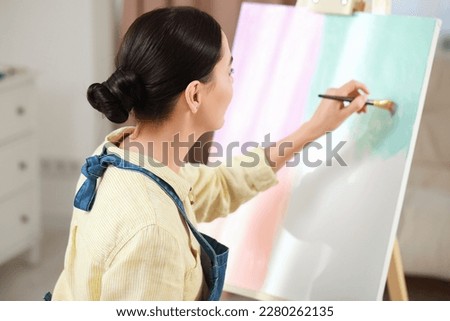 Woman painting on easel. Time for hobby