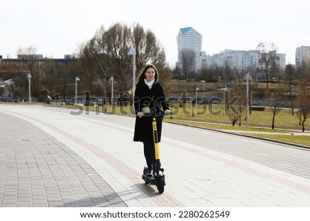 a girl rides a yellow electric scooter through the spring city