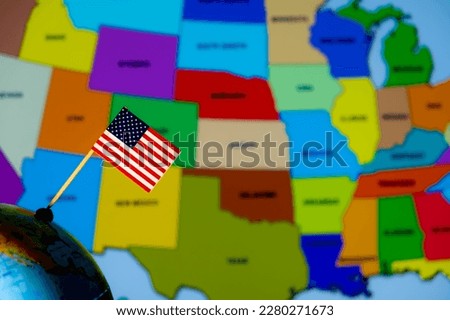 The national flag of the United States on the globe on the background of the map.