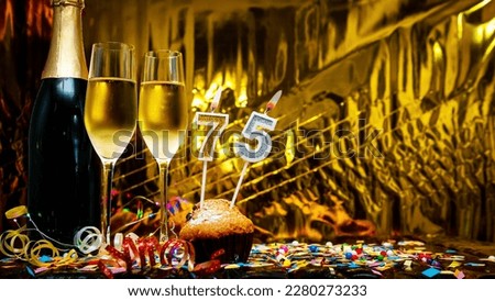 Copy space solemn background. Happy birthday golden background with number  75. Greeting card or postcard with a bottle of champagne with poured champagne in glasses.