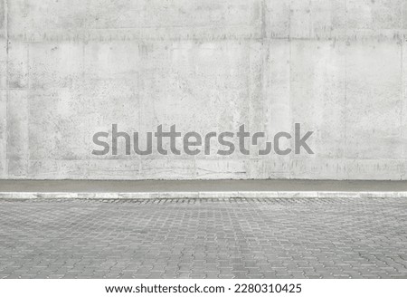 a fragment of a street city concrete wall of a building and an paving stones. Building's facade. Mocap or background for creativity Royalty-Free Stock Photo #2280310425