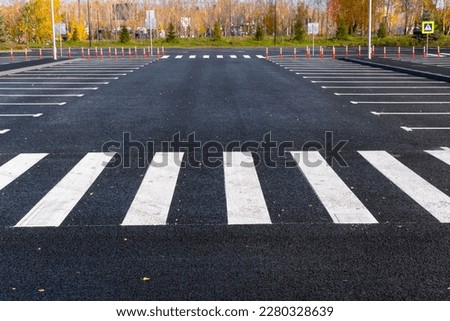The white and yellow lines of the pedestrian crossing at the intersection of roads in the city. Road safety. Zebra road markings, crossing point of the road, traffic rules Royalty-Free Stock Photo #2280328639