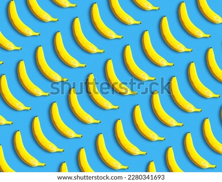 Beautiful fresh bananas lie on a blue background, pattern. Vitamins and fruits, creative idea