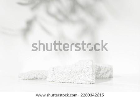 Neutral white product presentation podium and display made with porous stones on white background. Studio photography.