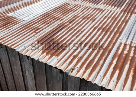 Old barn with a rusty corrugated iron roof and wooden plank sides, viewed from above Royalty-Free Stock Photo #2280366665