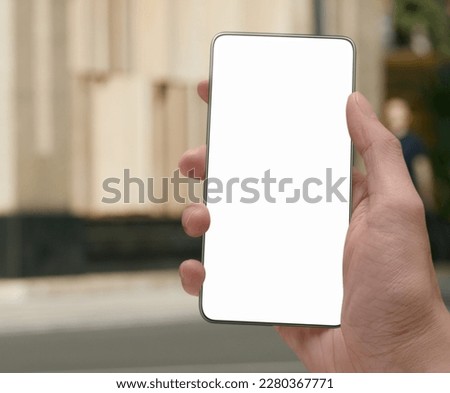 Selective focus close-up image of male hands using modern smartphone device in urban city shopping street reading social networks, sms message and checking e-mail. Product staging screen space mock-up Royalty-Free Stock Photo #2280367771