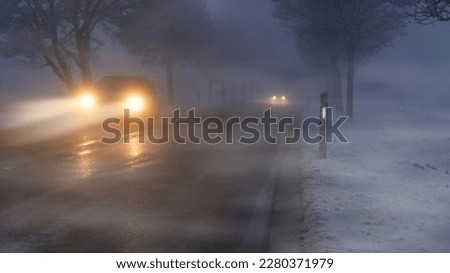Cars in winter in fog and poor visibility. Royalty-Free Stock Photo #2280371979
