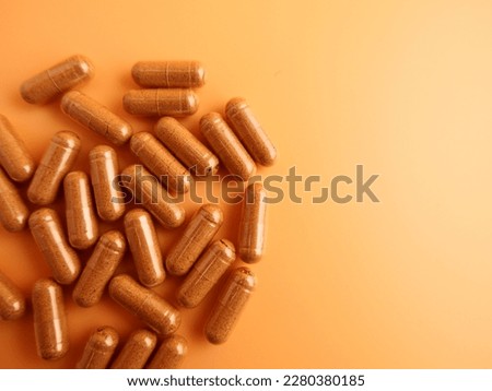 thai herbal capsules for the treatment of colds. Take pictures on a light orange background and right space for text.