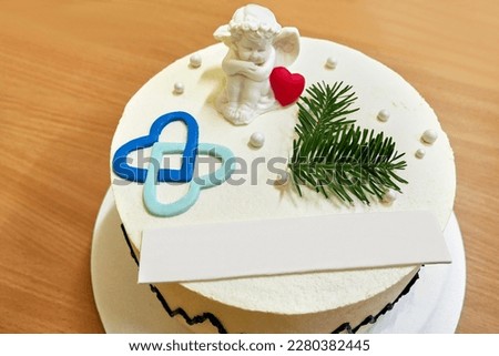 The festive cake is decorated with an angel, hearts and a pine branch.