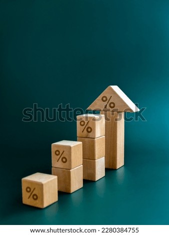 Percentage icon on wooden cube blocks bar graph chart steps with big arrowhead on blue background, vertical. Investment, income, trends, inflation, business growth, economic improvement concepts.