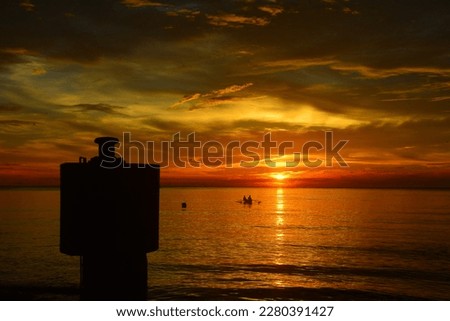 silhouette of two fisherman fishing in a boat with Beautiful sun background