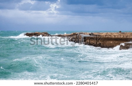 Coastal landscape with stormy sea waves under cloudy sky. Alexandria, Egypt