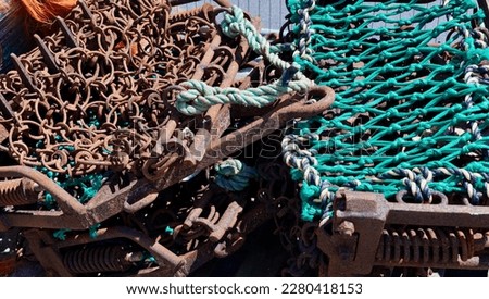 Metal chains and nets for use by fishing trawlers stacked on dockside with chains Royalty-Free Stock Photo #2280418153