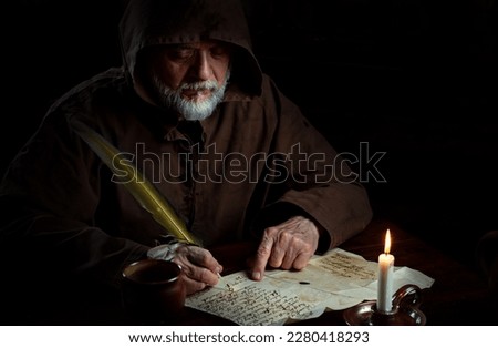 Old monk in the Middle Ages writes message Royalty-Free Stock Photo #2280418293