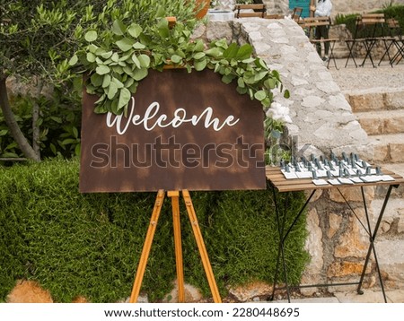 Plaque with inscription greeting guests at wedding. Welcome inscription sign wedding decorations. Wedding decor outdoor marriage