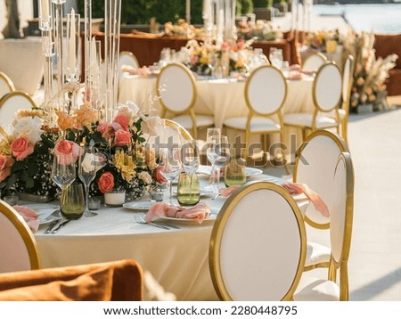 Wedding banquet concept. Chairs and round table for guests, served with cutler and, flowers and crockery and covered with a tablecloth Royalty-Free Stock Photo #2280448795