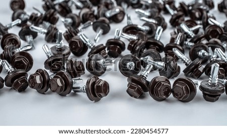 Self-tapping screws for fixing the metal profile sheet systems with brown hex heads. Selective focus. Royalty-Free Stock Photo #2280454577