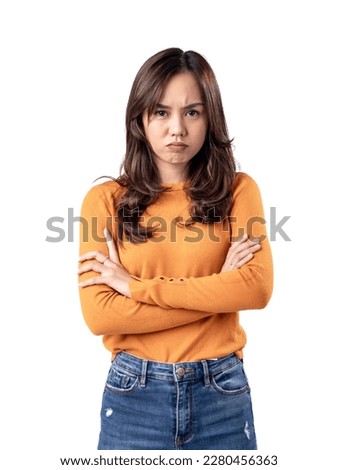 A portrait of an Asian Indonesian woman wearing an orange sweater and looking unhappy, folding her arms, isolated on a white background Royalty-Free Stock Photo #2280456363