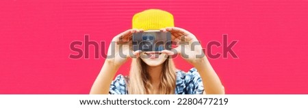 Close up of modern young woman stretching her hands taking selfie with smartphone on pink background